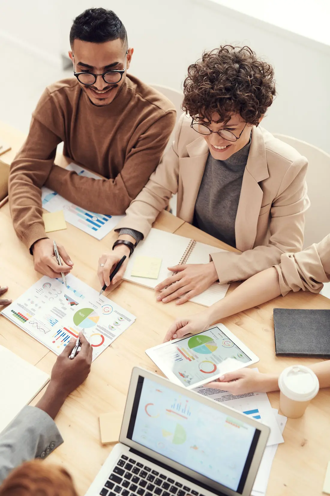 Hands resting on printed planning documents and charts spread across a desk